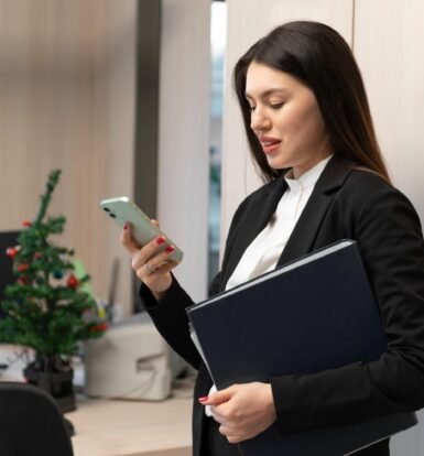 A professional woman in a business suit tracking an H-1B petition delivery on her phone while holding legal documents.