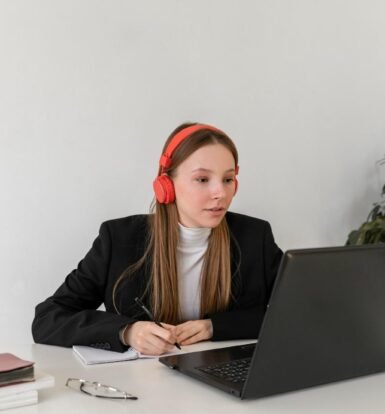 A professional virtual paralegal wearing red headphones, reviewing I-797 approval documents on a laptop, ensuring USCIS compliance.