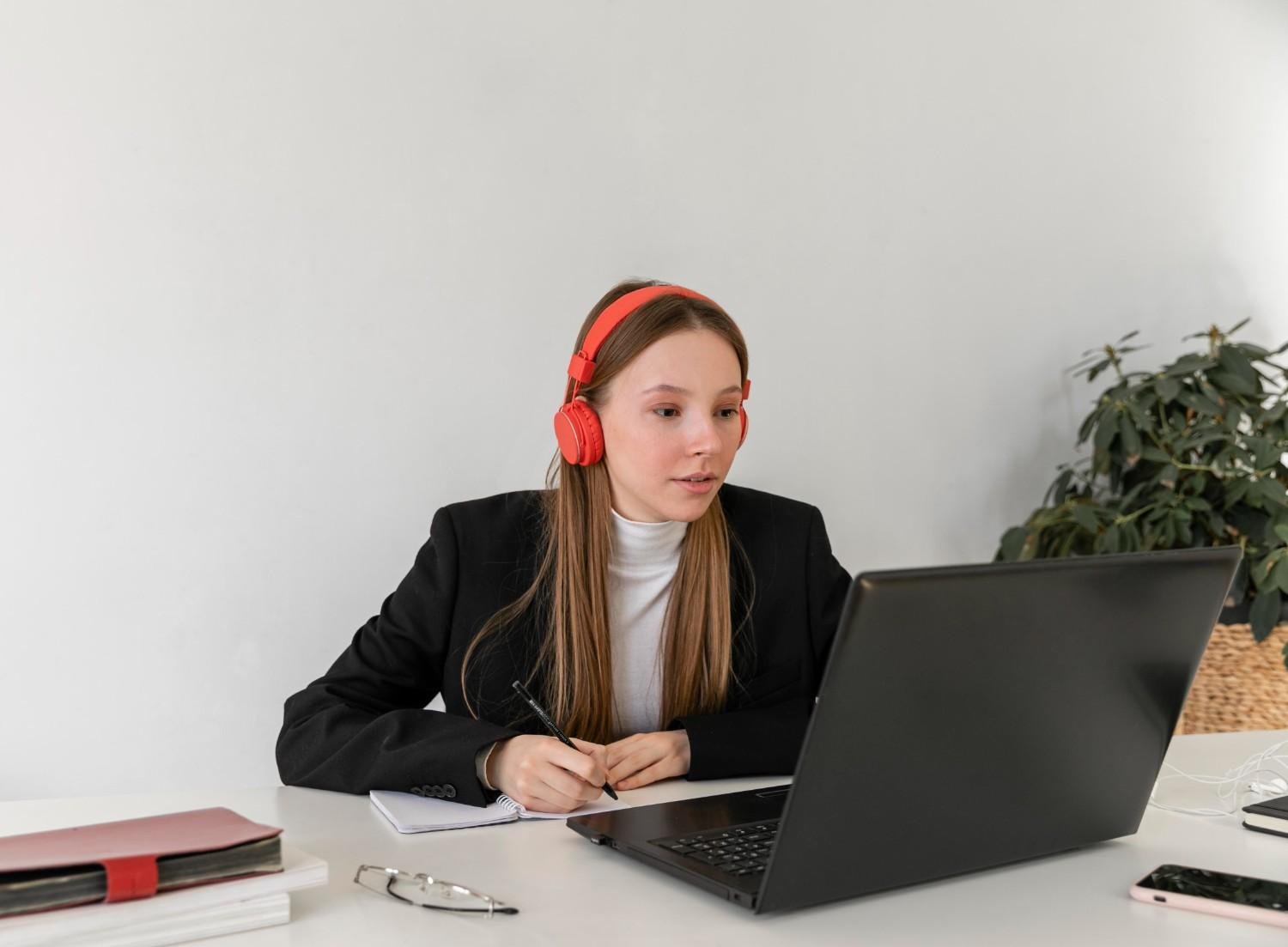 A professional virtual paralegal wearing red headphones, reviewing I-797 approval documents on a laptop, ensuring USCIS compliance.