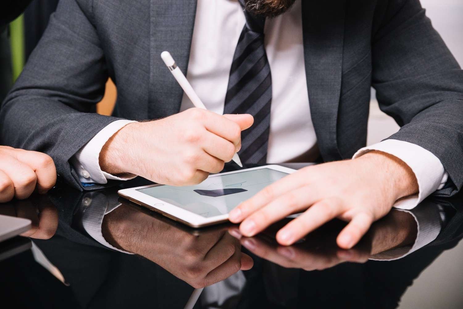 Immigration attorney using a tablet and stylus to review and organize documents with the help of virtual paralegals for USCIS petition submissions.