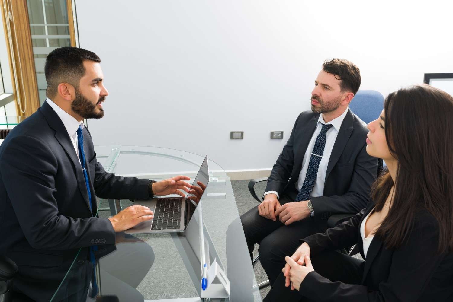 Immigration attorney discussing case details with clients in a meeting