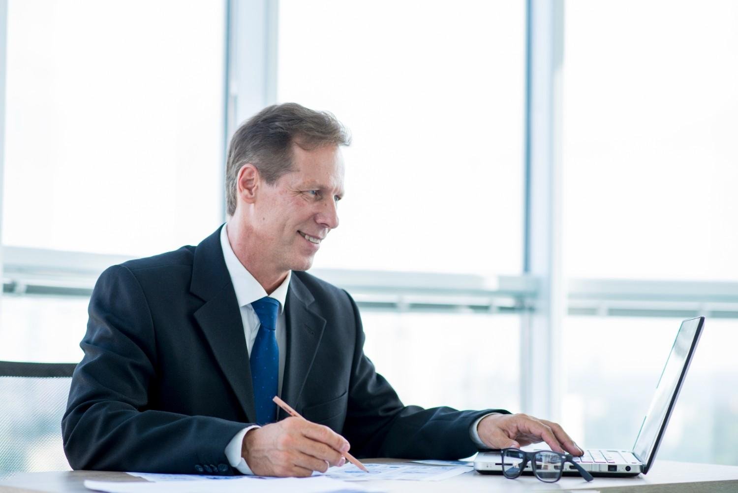 Professional man working on a laptop and tracking USCIS case status updates with virtual paralegal assistance.