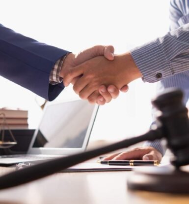 Lawyer and client shaking hands in an office, symbolizing trust and effective legal communication.