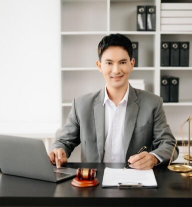 Confident lawyer working efficiently with a laptop and legal documents, representing the benefits of Virtual Legal Assistants for Law Firms.