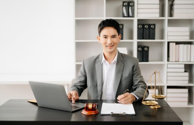 Confident lawyer working efficiently with a laptop and legal documents, representing the benefits of Virtual Legal Assistants for Law Firms.
