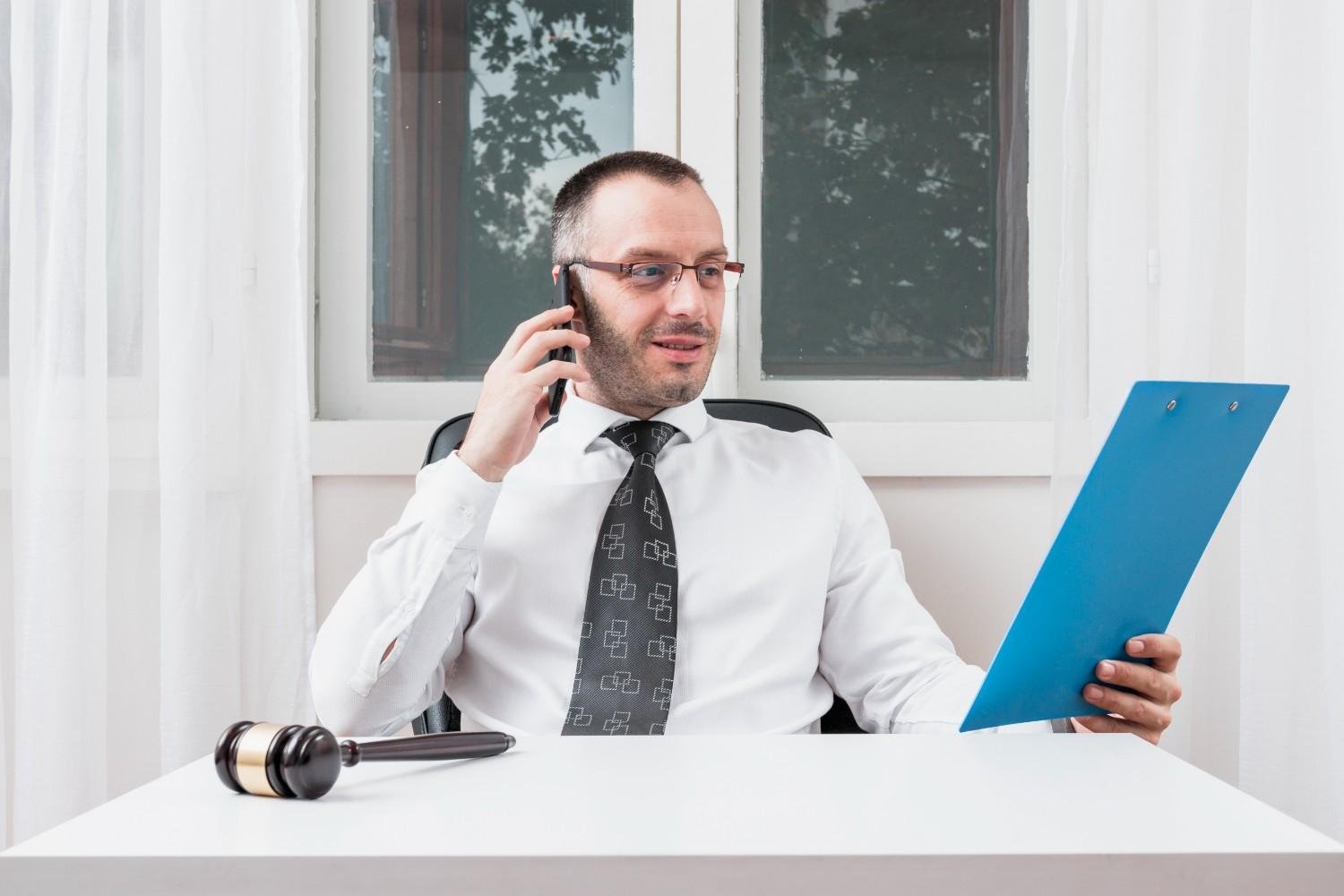 Immigration attorney reviewing H-4 visa application documents while on a call.