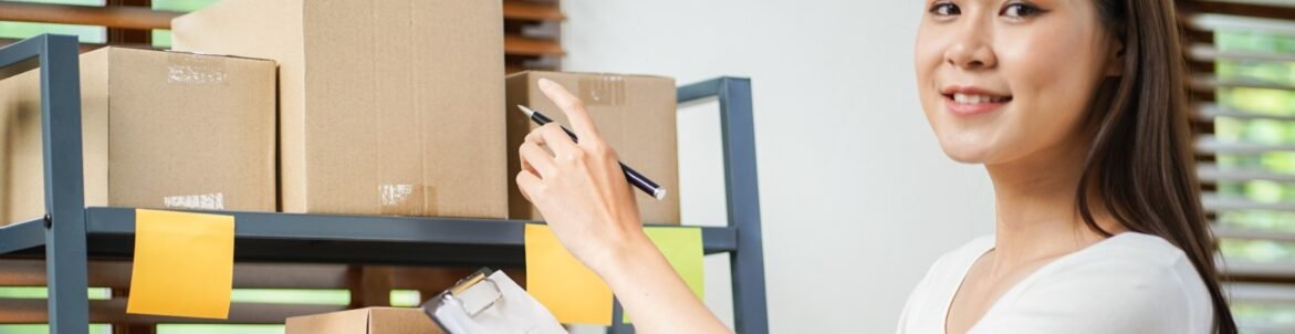 Smiling domestic mailing assistant organizing packages and checking shipping labels in an immigration law firm’s mailroom.